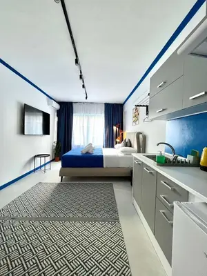 a bedroom with a bed and a kitchen with a sink at Plaka Voulis 45 by Zeus Suites in Athens