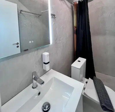 a bathroom with a sink and a toilet and a mirror at Plaka Voulis 45 by Zeus Suites in Athens