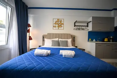 a blue bed with two white towels on it at Plaka Voulis 45 by Zeus Suites in Athens