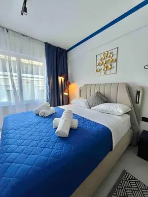 a bedroom with a blue and white bed with towels on it at Plaka Voulis 45 by Zeus Suites in Athens