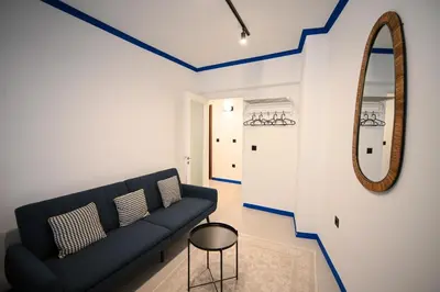 a living room with a black couch and a mirror at Syntagma Center Suite by Zeus Suites in Athens