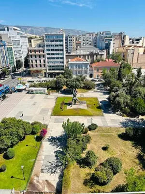 a park with a statue in the middle of a city at Acropolis view family big veranda by Zeussuites in Athens