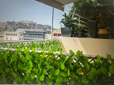 a balcony with green plants on a roof at Acropolis view family big veranda by Zeussuites in Athens