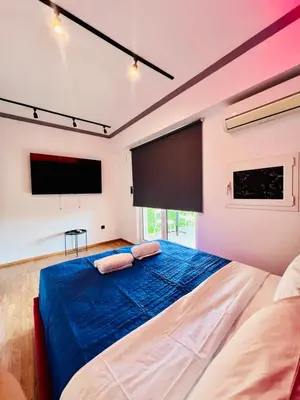 a bedroom with a large bed with a large screen at Acropolis view family big veranda by Zeussuites in Athens