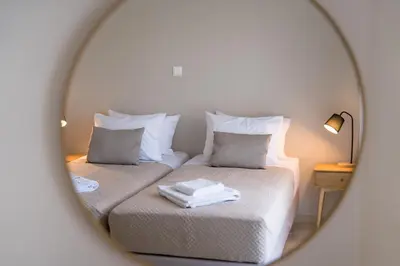 a mirror reflection of a bedroom with two beds at Mets-Athenian Horizon Escape in Athens