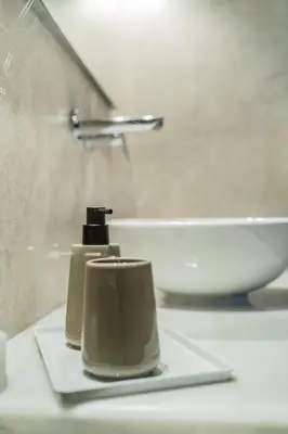 a bathroom sink with two soap dispensers on a counter at Mets-Athenian Horizon Escape in Athens