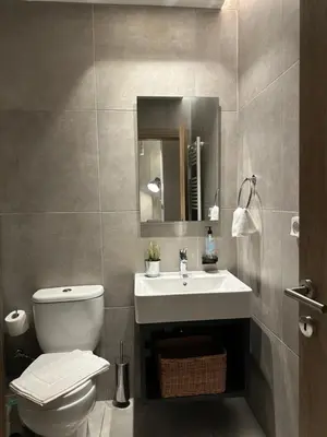 a bathroom with a sink and a toilet and a mirror at Urban Muse V - Archaeological Museum of Athens in Athens