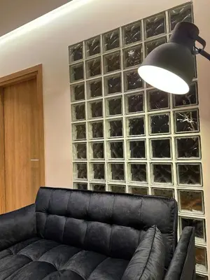 a black couch in a room with a wall of wine glasses at Urban Muse V - Archaeological Museum of Athens in Athens