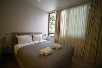 two towels on top of a bed with a window at Tsakalof 10 Kolonaki by Zeus Suites in Athens