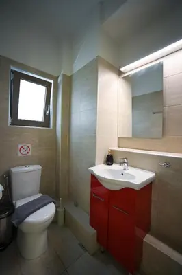 a bathroom with a white toilet and a sink at Tsakalof 10 Kolonaki by Zeus Suites in Athens