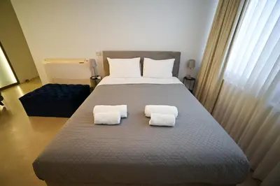 a bedroom with a large bed with two towels on it at Tsakalof 10 Kolonaki by Zeus Suites in Athens
