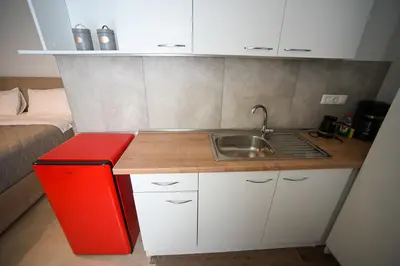 a small kitchen with a sink and a red refrigerator at Tsakalof 10A Elegant Studio by Zeus Suites in Athens