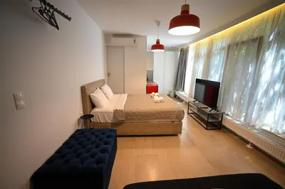 a bedroom with a bed and a couch and a tv at Tsakalof 10A Elegant Studio by Zeus Suites in Athens