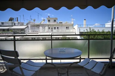 a table and chairs on a balcony with a building at Tsakalof 10 Veranda Kolonaki by Zeussuites in Athens