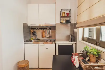 a small kitchen with white cabinets and a sink at Tsakalof 10 Veranda Kolonaki by Zeussuites in Athens
