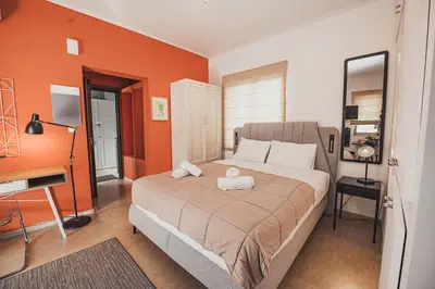 a bedroom with a bed with an orange wall at Tsakalof 10 Veranda in Athens