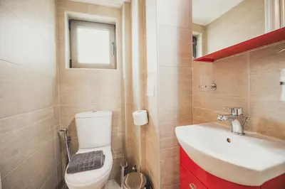 a bathroom with a toilet and a sink and a window at Tsakalof 10 Veranda in Athens