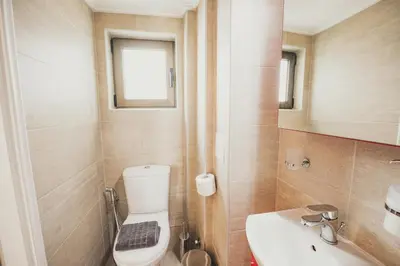 a bathroom with a toilet and a sink and a window at Tsakalof 10 Veranda in Athens