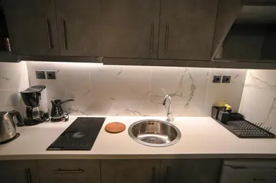 a kitchen counter with a sink and a stove at Monastiraki Athens Luxe Suite by Zeus Suites in Athens