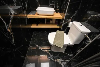 a bathroom with a white toilet and a sink at Monastiraki Athens Luxe Suite by Zeus Suites in Athens