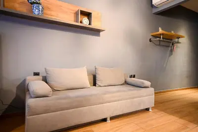 a couch with three pillows on it in a room at Monastiraki Athens Luxe Suite by Zeus Suites in Athens