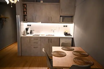 a kitchen with a wooden table with chairs and a sink at Monastiraki Athens Luxe Suite by Zeus Suites in Athens