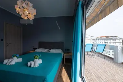 a room with a bed and a balcony with chairs at Acropolis Majestic View Residence Aiolou 97 by Zeussuites in Athens