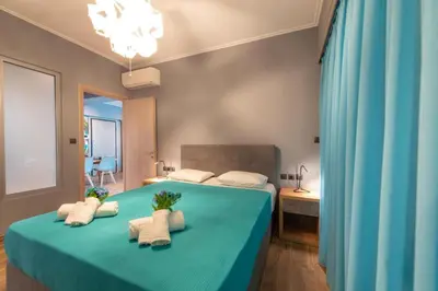 a bedroom with a blue bed with towels on it at Acropolis Majestic View Residence Aiolou 97 by Zeussuites in Athens