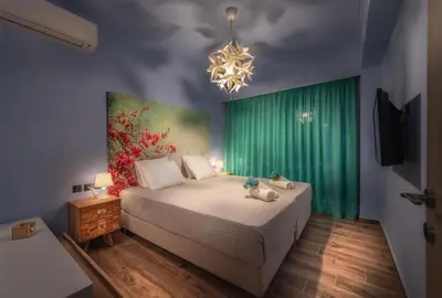 a bedroom with a bed and a chandelier at Acropolis Majestic View Residence Aiolou 97 by Zeussuites in Athens