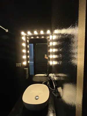 a bathroom with a white sink and a mirror at Tsakalof 17 Black in Athens