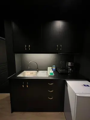 a kitchen with black cabinets and a sink at Tsakalof 17 Black in Athens
