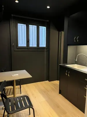 a kitchen with a table and a chair and a sink at Tsakalof 17 Black in Athens