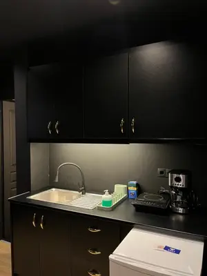 a kitchen with black cabinets and a sink at Tsakalof 17 Black in Athens