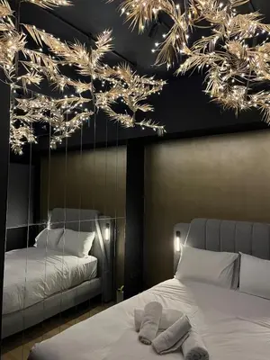 a bedroom with a bed and a mirror with lights at Tsakalof 17 Black Suite by Zeus Suites in Athens