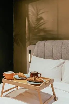 a coffee table with two pastries on a bed at Tsakalof 17 Black Suite by Zeus Suites in Athens