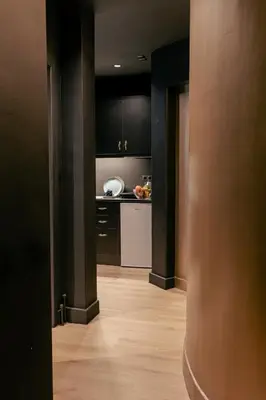 a kitchen with black cabinets and a wooden floor at Tsakalof 17 Black Suite by Zeus Suites in Athens