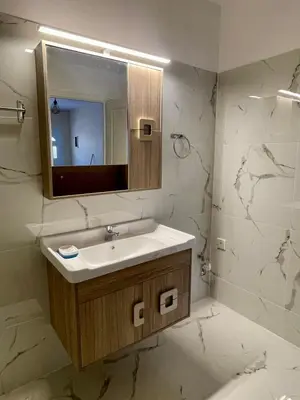 a bathroom with a sink and a mirror at Ivory Escape Apartment - ATH Airport in Spáta