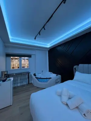 a bedroom with a white bed and a bath tub at Tsakalof 17 Jacuzzi Kolonaki Suite by Zeus Suites in Athens