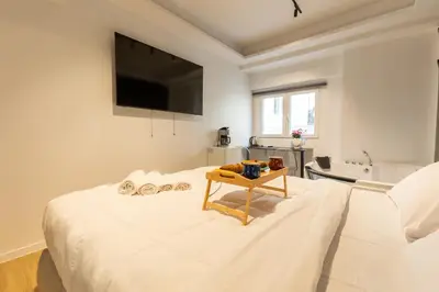 a bedroom with a bed with a tv on the wall at Tsakalof 17 Jacuzzi Kolonaki Suite by Zeus Suites in Athens