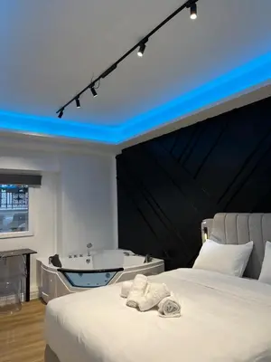 a bedroom with a bath tub and a bed at Tsakalof 17 Jacuzzi Kolonaki Suite by Zeus Suites in Athens