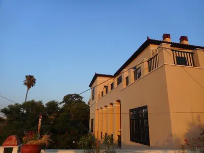 a yellow building with a palm tree in the background at Nanny's Guest House in Plaka in Athens