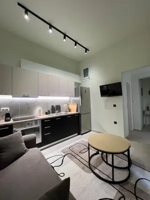 a living room with a couch and a table and a kitchen at Modern apartment with patio in Athens