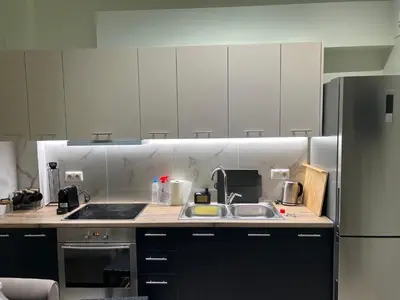 a kitchen with a sink and a refrigerator at Modern apartment with patio in Athens