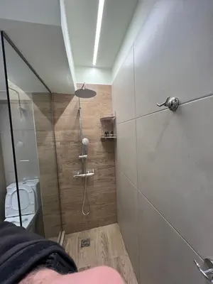 a bathroom with a shower and a toilet at Modern apartment with patio in Athens