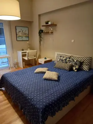 a bedroom with a blue bed with two pillows on it at Kolonaki hug in Athens