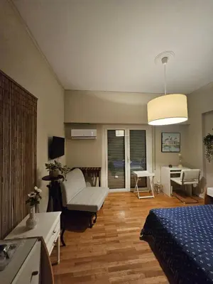 a bedroom with a bed and a living room with a couch at Kolonaki hug in Athens