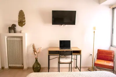 a room with a desk and a television on a wall at Studio in trendy Pagkrati district in Athens