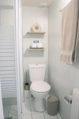 a white bathroom with a toilet and a towel at Studio in trendy Pagkrati district in Athens