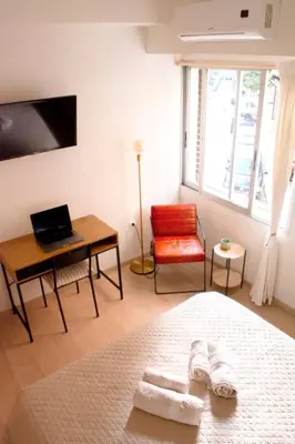 a bedroom with a bed and a desk and a chair at Studio in trendy Pagkrati district in Athens