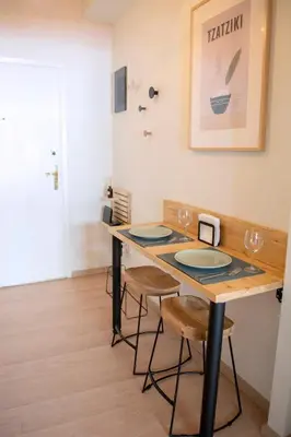 a dining room table with two chairs and a table with glasses at Studio in trendy Pagkrati district in Athens